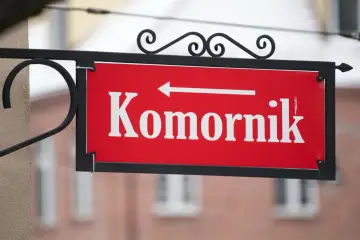 Czerwona tabliczka z napisem "Komornik" i strzałką w lewo. Pamiętaj, czego nie może zabrać komornik z mieszkania!
